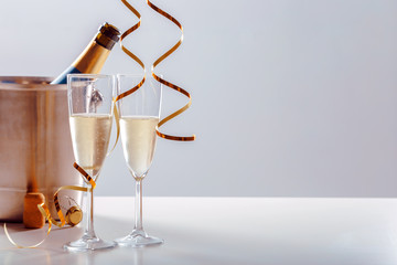 Pair glass of champagne with bottle in metal container. New Year celebration