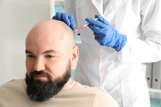 Man With Hair Loss Problem Receiving Injection In Clinic