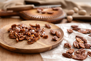 Candied pecan nuts on wooden plate