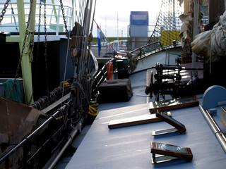 dutch flat bottom boat moored at Texel harbour next to a shipping vessel