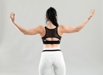 Sporty muscular woman on grey background