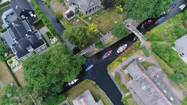 Aerial footage of busy canal in Giethoorn is town in province of Overijssel Holland and is often referred to as the Venice of the Netherlands because of the popular canals with tourist tour boats 4k