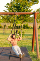 Young man with six-pack exercising in the park