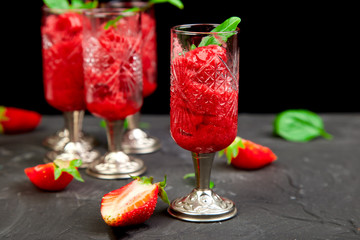 Summer refreshing strawberry sorbet, slush granita drink in serving glasses.