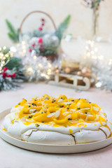 Meringue cake Pavlova with fresh mango and passion fruit and whipped cream on slate, stone or concrete background
