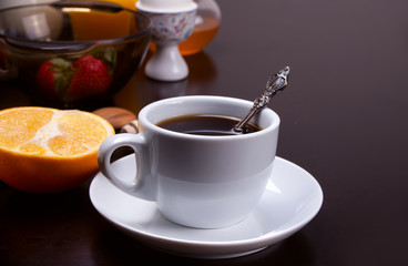 Cup of coffee and fruits and berries on the wooden table