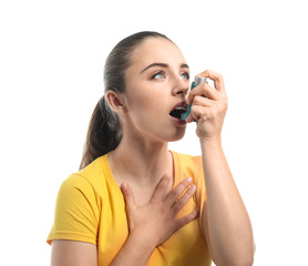 Young woman with inhaler having asthma attack on white background