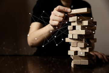 business man try to build wood block under social network on wooden table and black background business organization startup concept