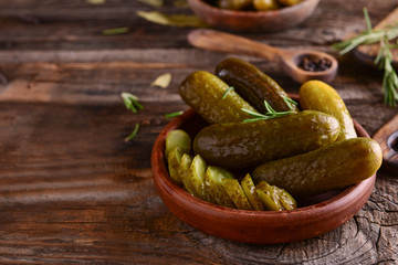 Plate with tasty fermented cucumbers on wooden table