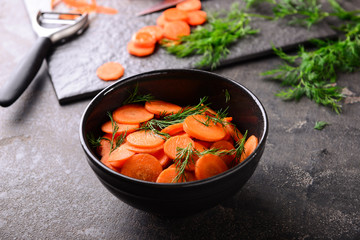 Bowl with tasty fermented carrot on grey table