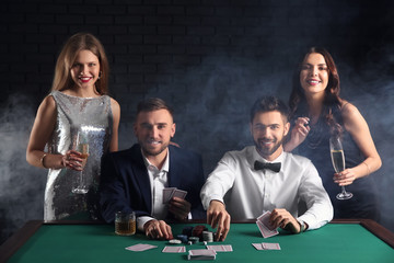 Group of poker players at table in casino