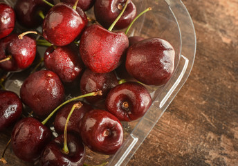 Plastic packaging full of fresh red juicy cherries.