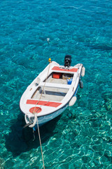 White boat at crystal clear blue water of Marmara beach, near Aradena gorge, island of Crete, Greece