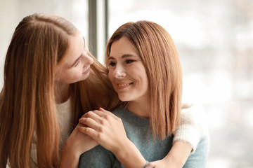 Portrait of happy mother and daughter near window