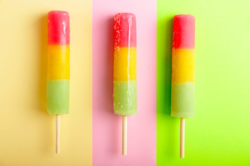 Delicious popsicles on color background