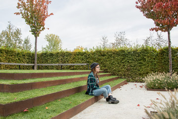 Fototapeta premium young womnan with red dreadlocks amd glasses relaxing in the autumn park 