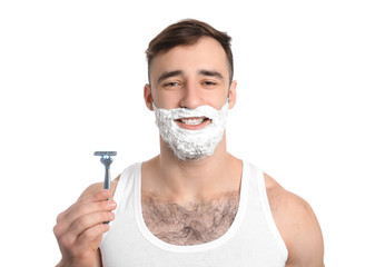 Handsome man with shaving foam on his face and razor against white background