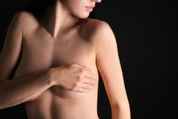 Young woman with beautiful breast on dark background