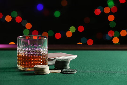 Chips, glass of whiskey and cards on table in casino