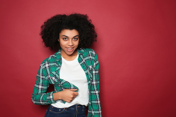 Portrait of young African-American woman on color background