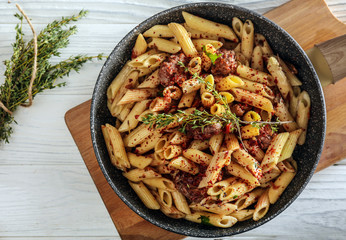 Tasty pasta with meat and spices in pan on table