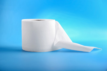Roll of toilet paper on color background