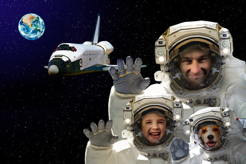 Portrait of a man with a child and a dog in space against the background of the space shuttle and the planet Earth. Elements of this image furnished by NASA.
