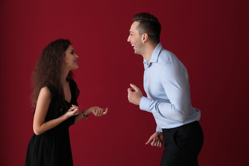 Young couple dancing against color background