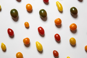 Many colorful tomatoes on white background