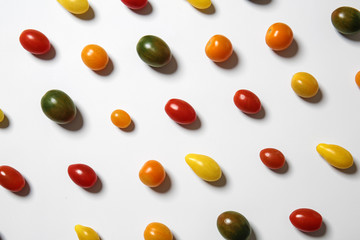 Many colorful tomatoes on white background