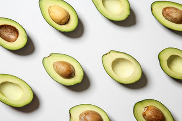 Plenty of fresh avocados on white background