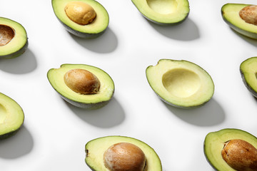 Plenty of fresh avocados on white background