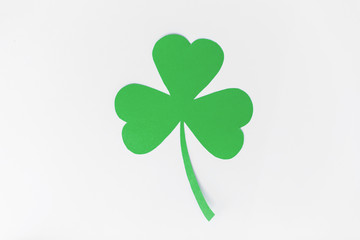 fortune, luck and st patricks day concept - green paper shamrock on white background