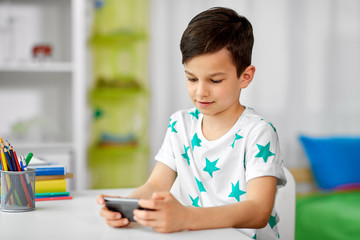 people, technology and communication concept - happy smiling boy with smartphone at home