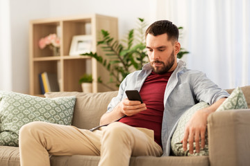 Fototapeta premium technology, internet and communication concept - man using smartphone at home
