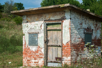 Old weathered grunge solid brick worked farm shed in sunny summer day