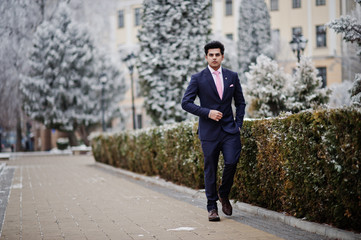 Elegant indian macho man model on suit and pink tie posed on winter day.