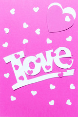 Layout card for the holiday Valentine's Day. Hearts of the word love from paper scrapbooking, origami, handmade on a pink background