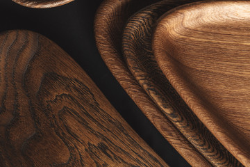 Wood texture, close up. Showing growth rings. Design boards made of solid wood. Set of cutting boards and wooden dishes made from of valuable timber on dark background.