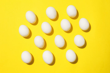 Many chicken eggs on color background