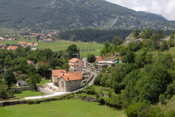 Fototapeta na wymiar Small Njegusi village in Montenegro, located on a green valley at the foot of the mountains