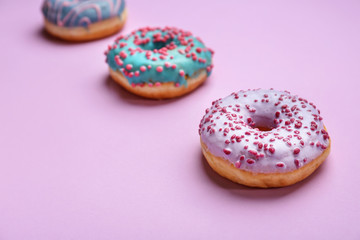 Sweet tasty donuts on color background