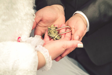 hands of bride and groom with vintage lock