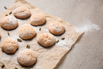 Parchment with tasty cookies on table