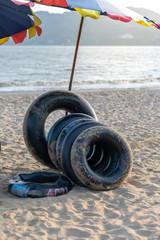 Group of black inflatable ring and parasol  at the beach in Thailand