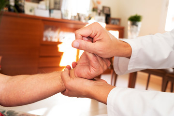 man moving the hand of a senior patient