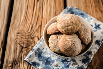 Bowl with tasty cookies on wooden table