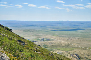 Beautiful panoramic summer steppe landscape of stone mountains "Monasteries" and "Aiyrtau" (1003 meters above sea level), near the town of Ust-Kamenogorsk in East Kazakhstan
