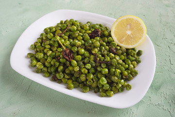 Baked green peas with spices. Indian dish.