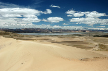 Fototapeta na wymiar Sandy hills and blue sky in Tibetan landscape